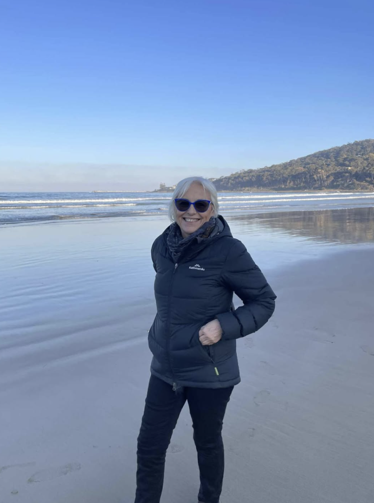 Dr. Beatriz Martini standing in nature near a lakeside landscape